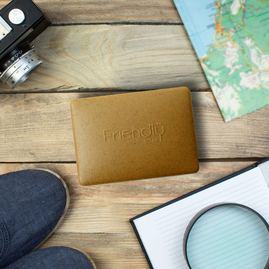 Friendly Soap Travel Box on a Layflat table photograph showing map, camera, shoes and diary.
