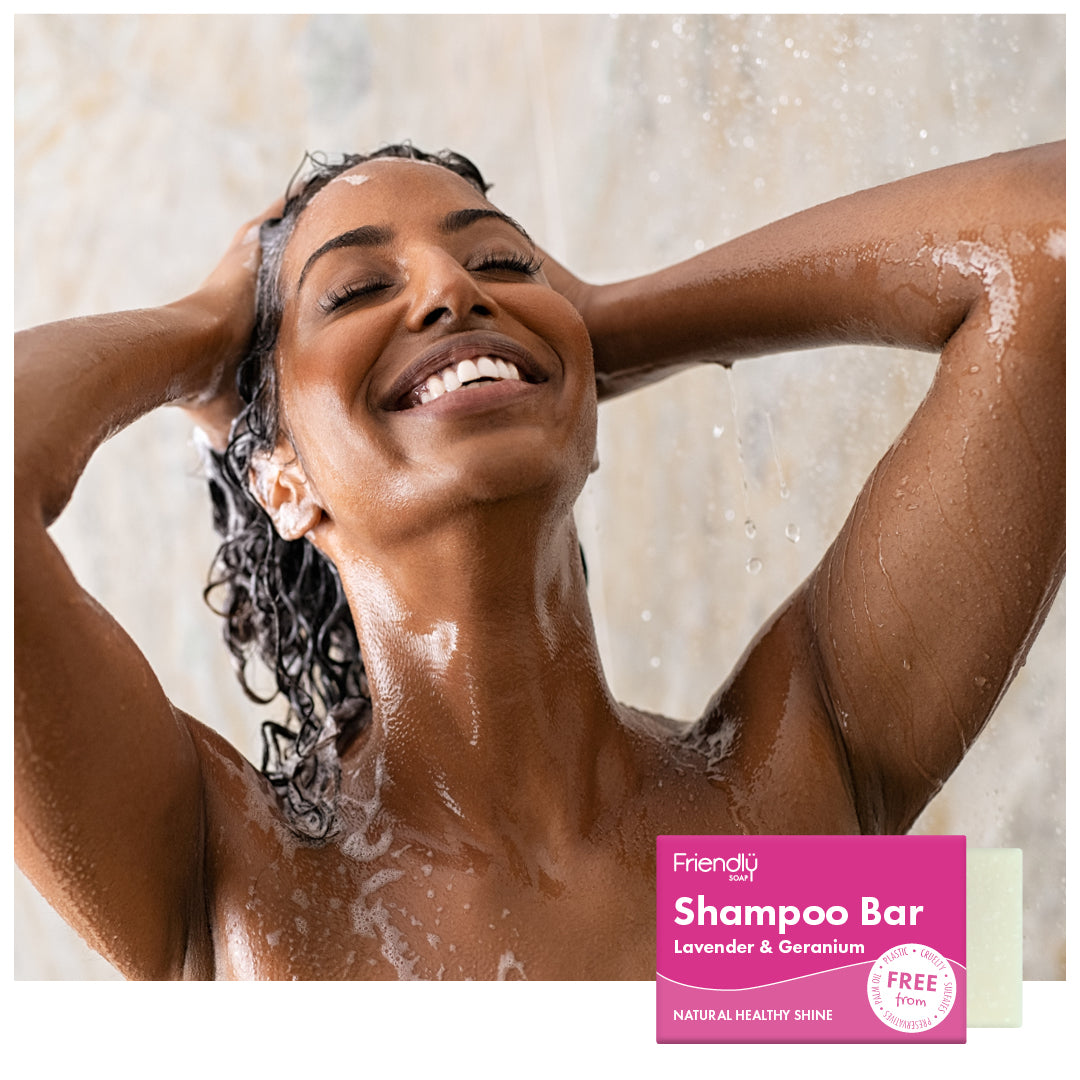 woman smiling and washing her hair in the shower