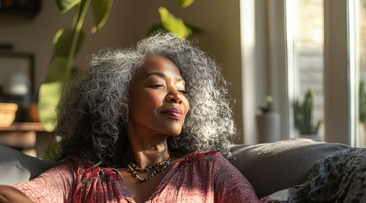 Mature Woman relaxing at home, enjoying the sun on her face.