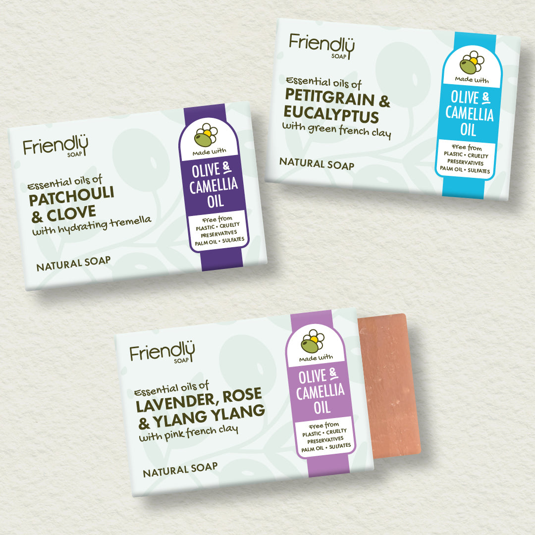 A close-up split portrait of two people' faces with the Friendly Soap 'Olive & Camellia Oil' soap bar package shown in the lower right corner.