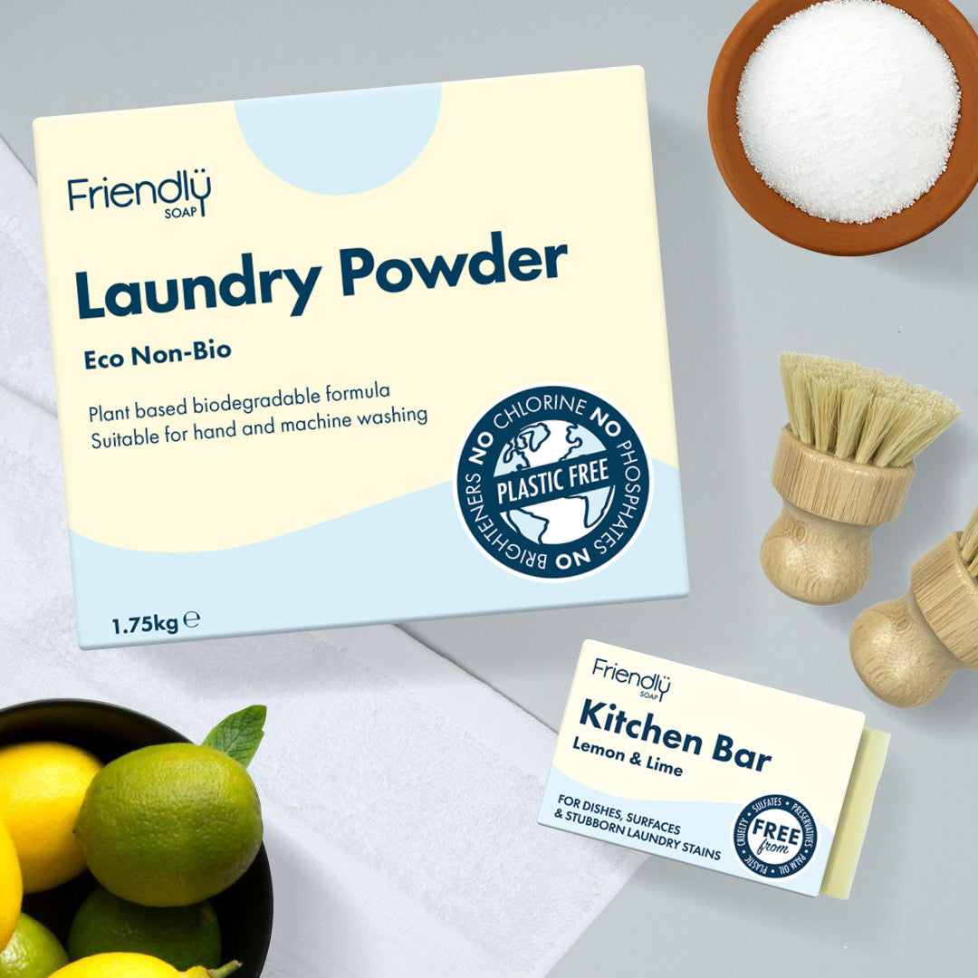 friendly soap eco non-bio laundry powder and kitchen bar on table with wooden scrubbing brushes