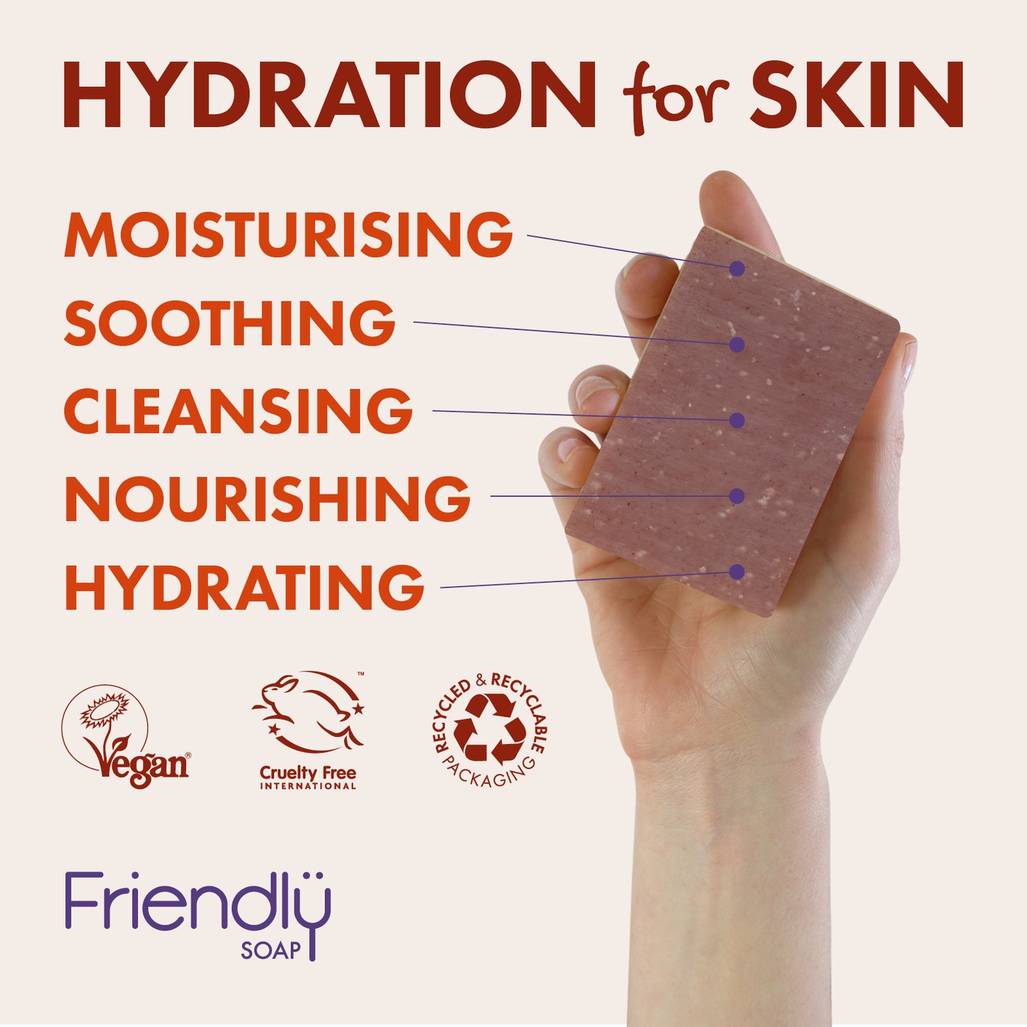 A hand holds a rectangular bar of pinkish-brown speckled soap against a light beige background with promotional text reading 'HYDRATION for SKIN' and feature labels: moisturising, soothing, cleansing, nourishing, hydrating. Logos for Vegan, Cruelty Free, and recycled packaging are shown at the bottom, along with the brand name Friendly Soap.
