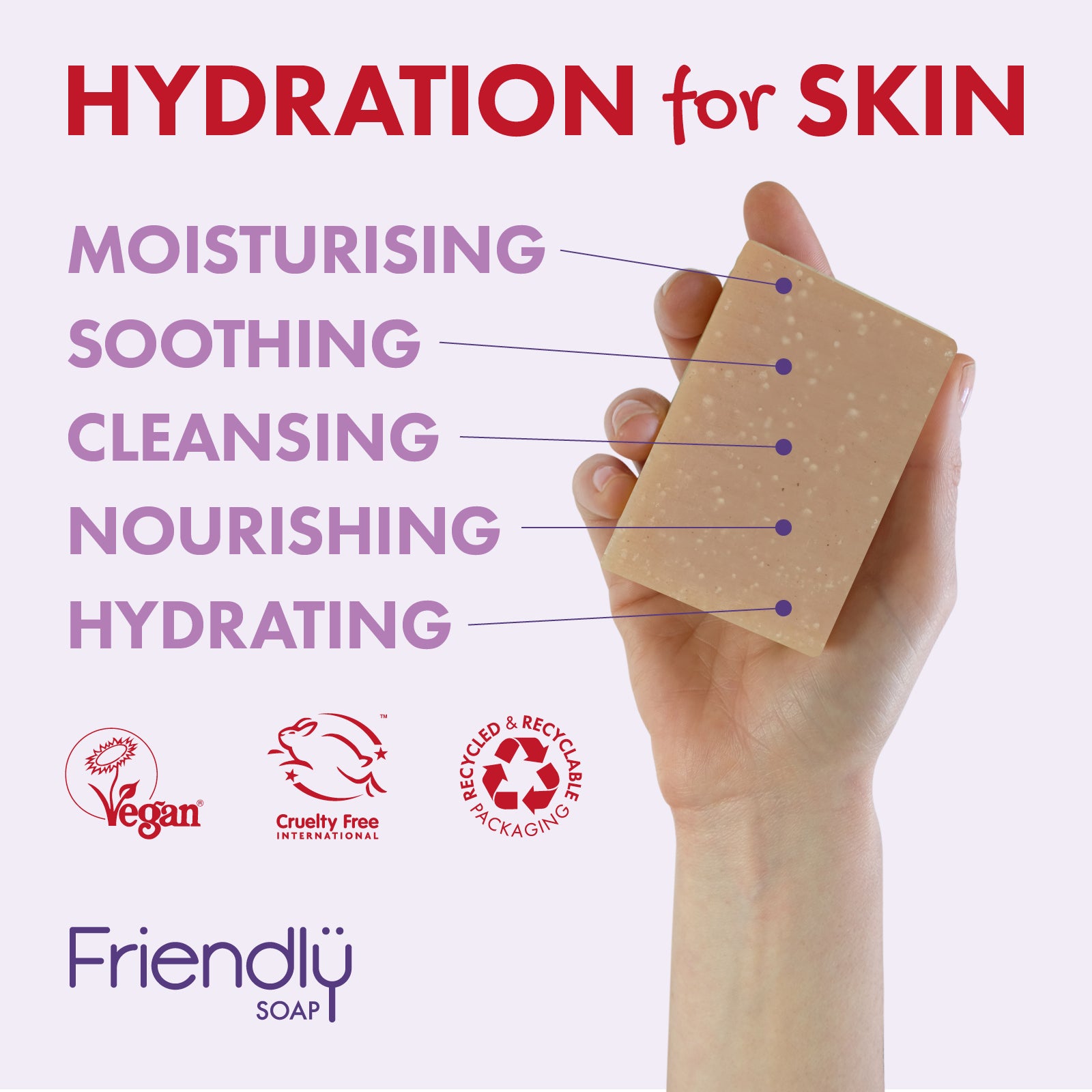 A hand holding a rectangular bar of beige moisturizing soap against a light background, with large red text reading 'HYDRATION for SKIN' and purple callouts listing moisturising, soothing, cleansing, nourishing, and hydrating benefits. Friendlü Soap branding and cruelty-free/vegan icons appear at the bottom.