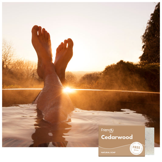 some feet relaxing at an outdoor spa with trees and a sunset in the background