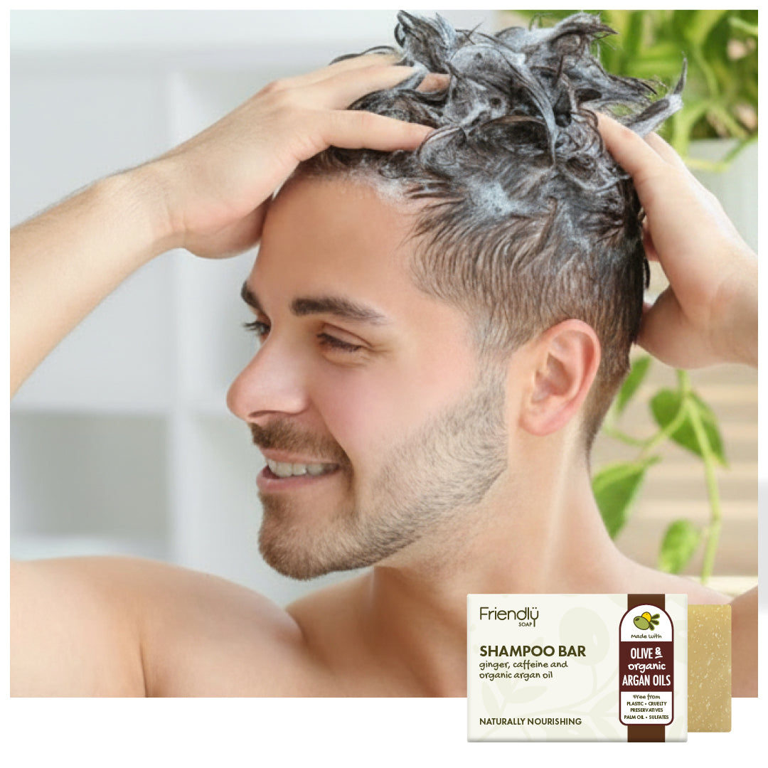 a young man smiling and washing his hair in the shower with a friendly soap shampoo bar