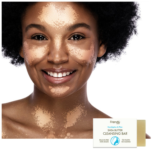 A smiling woman with a skincare is shown against a white background, with a small package of Friendly Shea Butter Cleansing Bar in the lower right corner.