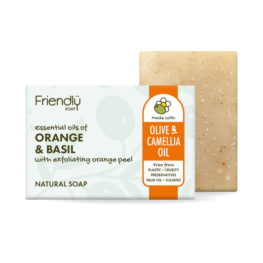 A bar of Friendly orange & basil soap shown with its retail packaging on a plain white background. The soap is labeled 'Olive & Camellia Oil' and is positioned behind the box, with the beige soap bar visible on the right.