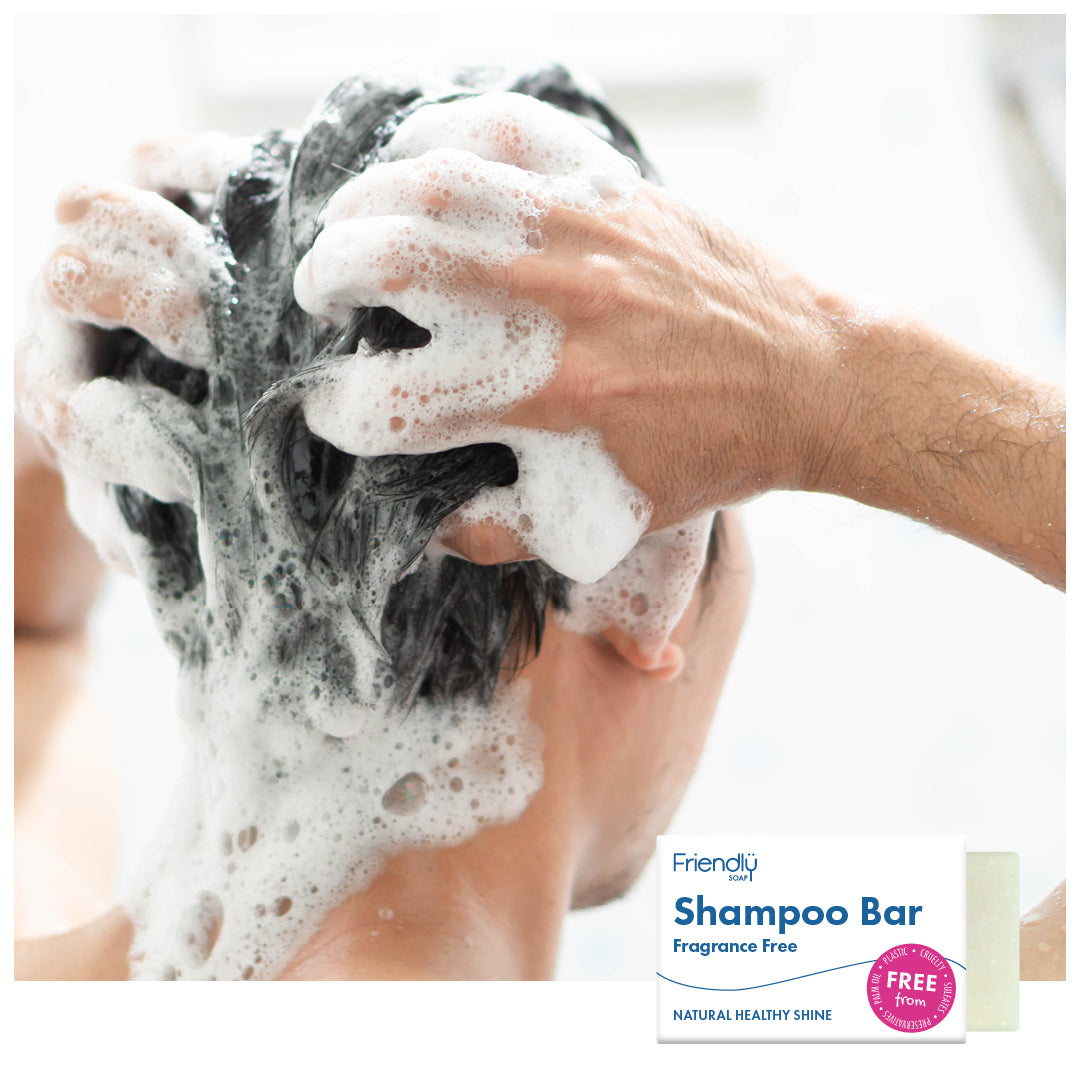 woman lathering her dark hair in the shower