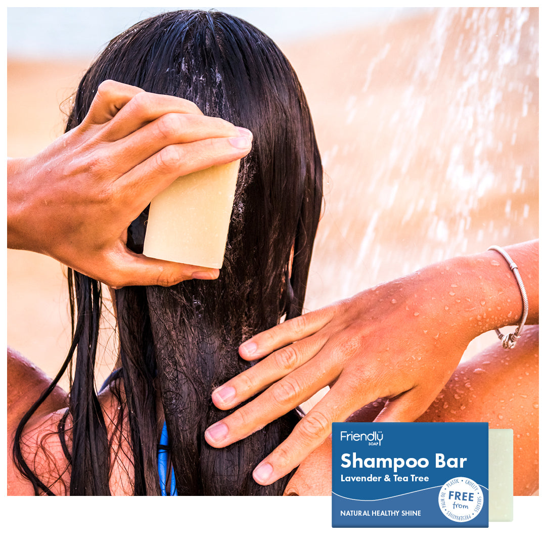 woman using shampoo bar outside under running water
