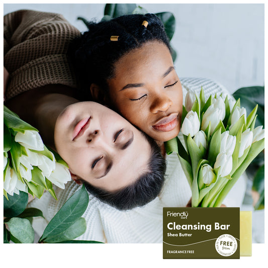 two young women with flowers, lay down with their faces next to each other.