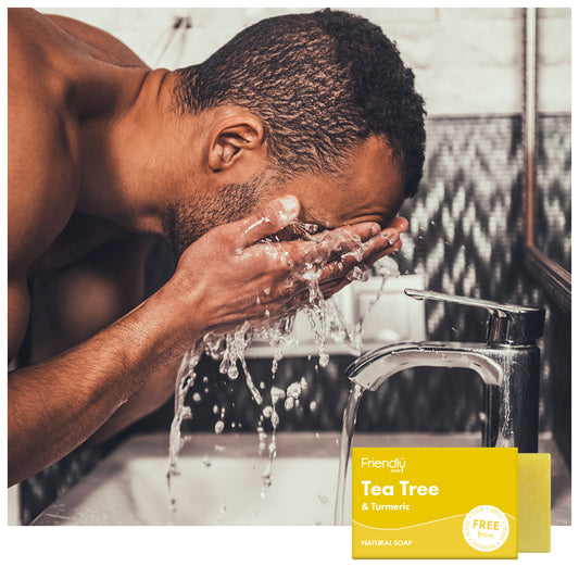 Man washing his face in the bathroom sink - tea tree and turmeric natural soap