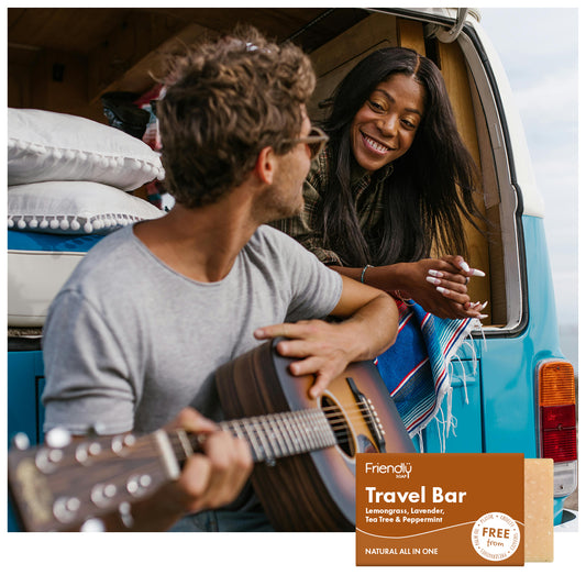 young couple with acoustic guitar in a camper van - friendly soap travel bar 