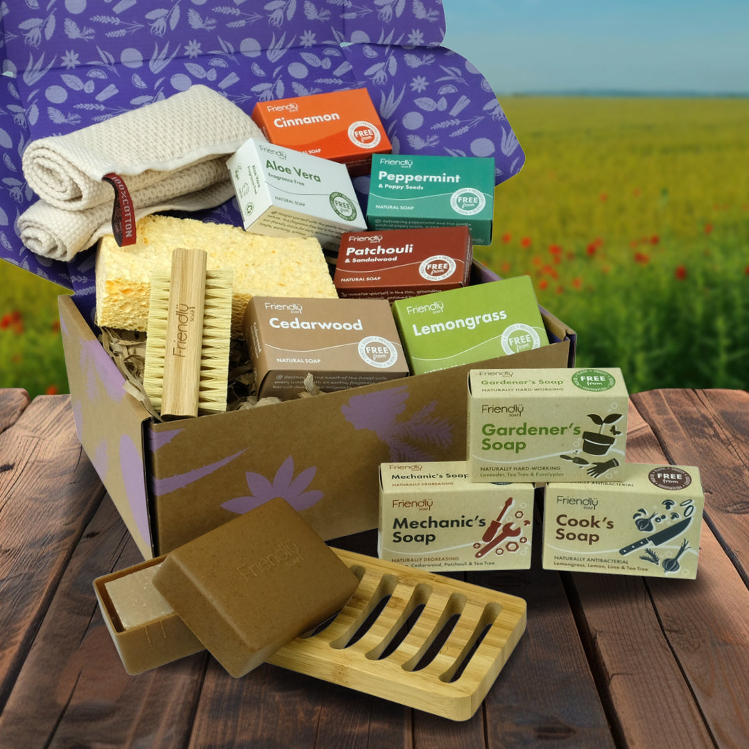 luxury eco lifestyle hamper on a garden table packed with plastic free friendly soap bars, nail brush, soap box, soap rack, sponge and waffle cloth.
